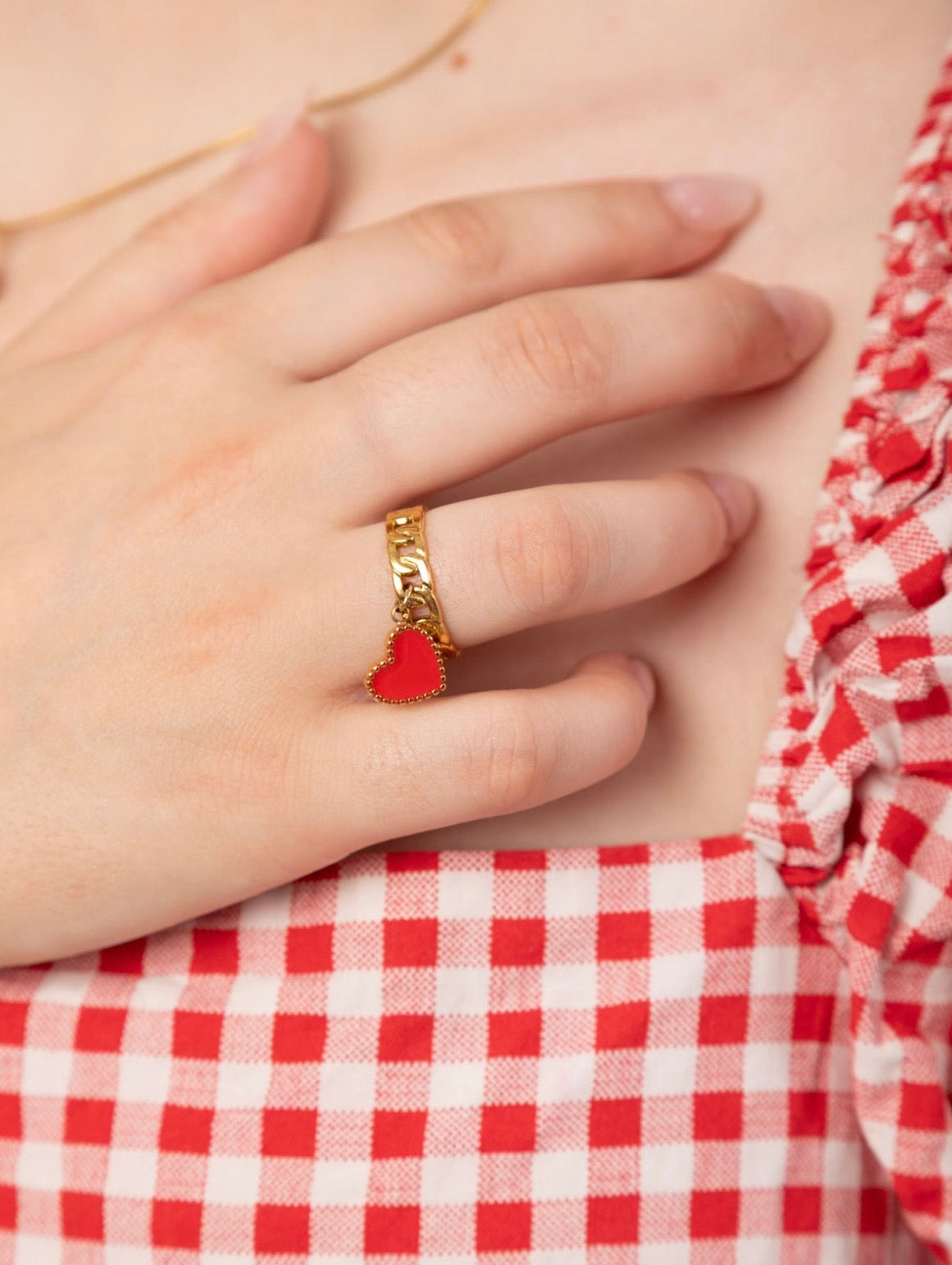 Gold chain ring with red heart charm worn on hand – Weekendplans