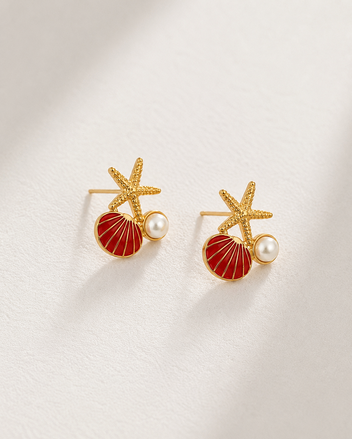 Capri Club gold starfish earrings with red shell and pearl detail