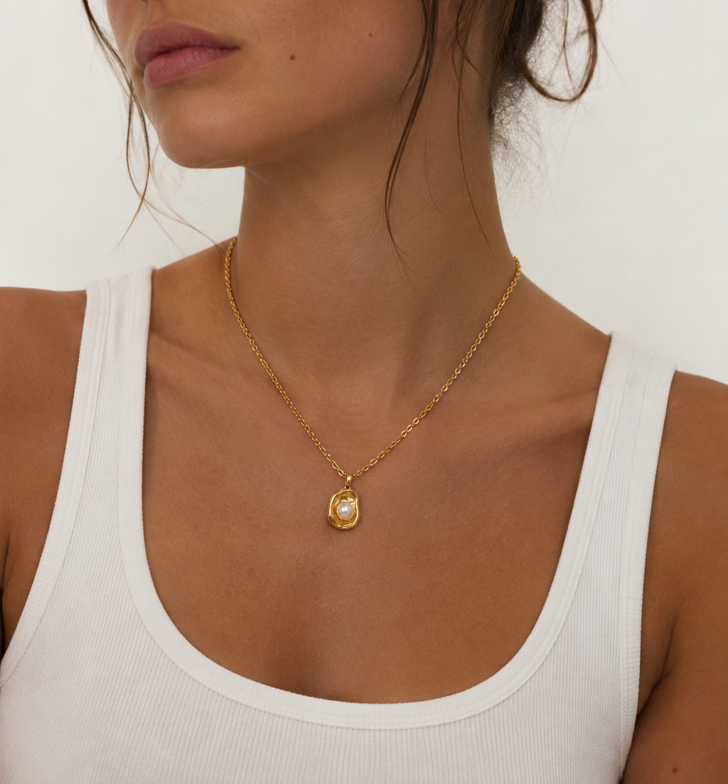 Model wearing gold Oyster Necklace with pearl pendant