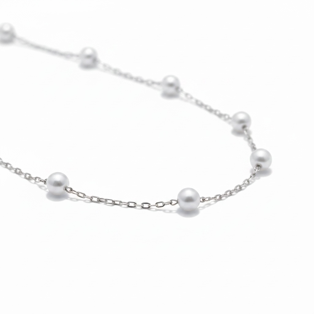 Close-up of silver pearl station necklace with delicate chain and spaced pearls – Weekendplans