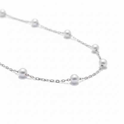 Close-up of silver pearl station necklace with delicate chain and spaced pearls – Weekendplans