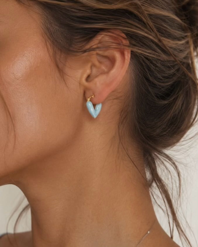 Model wearing Skye pale blue heart hoop earrings with gold detail